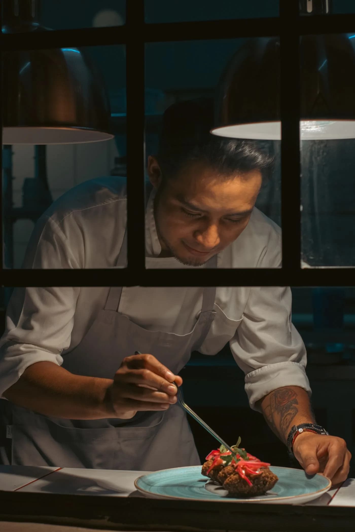 Chef carefully plating a dish during dinner service